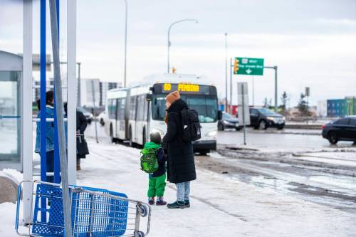 MIKAELA MACKENZIE / WINNIPEG FREE PRESS
                                Venera Sorkina and her son, Ivan, wait for the second bus on their way back home from Mosaic&rsquo;s English language class on Monday, Dec. 11, 2023. At this bus stop in the past they have had to go and warm up in a nearby McDonaldճ when multiple buses have been late or cancelled. For Malak story. Winnipeg Free Press 2023