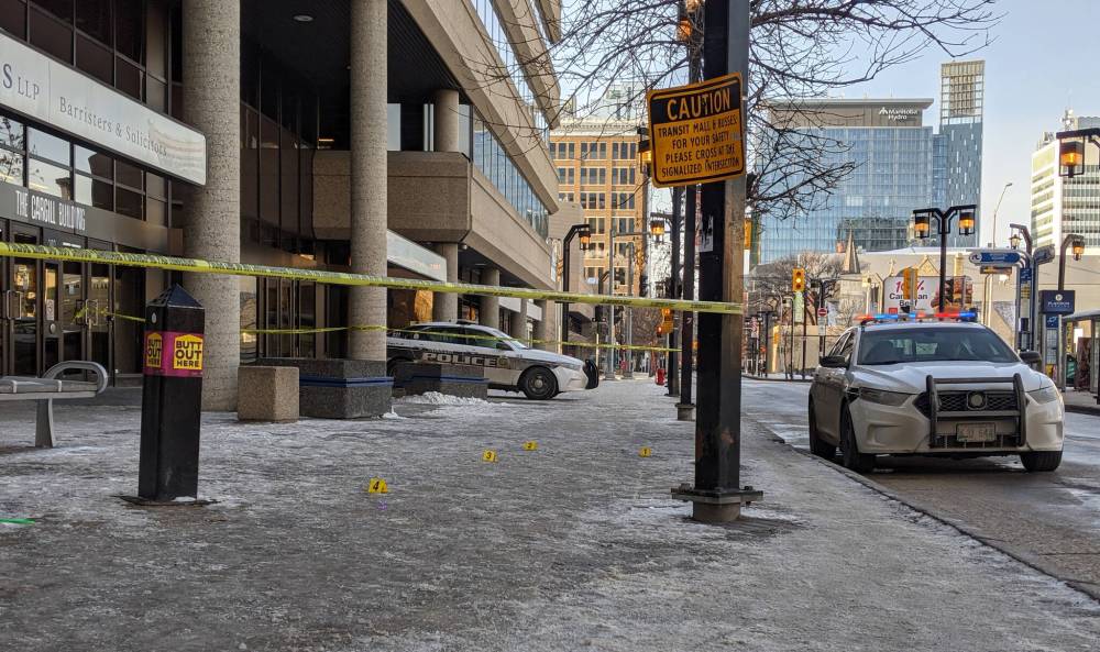 About a dozen yellow evidence markers were placed on the sidewalk in front of the Cargill Building Saturday after a 14-year-old girl was stabbed. (Chris Kitching / Winnipeg Free Press)