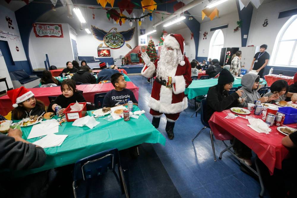 JOHN WOODS / WINNIPEG FREE PRESS Santa and volunteers with The Sons and Daughters of Italy host their annual Christmas Eve feast at Rossbrook House.