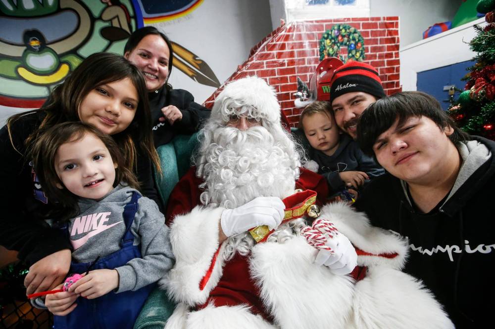 JOHN WOODS / WINNIPEG FREE PRESS Breanne Durocher and Willis Ducharme with their children, from left, Aubrey, Addisyn, Niko and Khaedon visit with Santa.