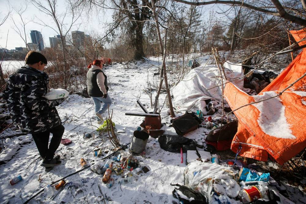 Mission Baptist Church volunteers Logan and Judy Anderson hand deliver meals to tent communities on Monday, the church also expected to serve about 500 meals on Christmas Day. (John Woods / Winnipeg Free Press)