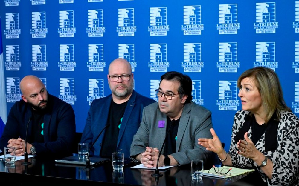 Magali Picard, right, of the FTQ union, speaks at a news conference of the common front, Thursday, Dec. 7, 2023, at the legislature in Quebec City. Eric Gingras of the CSQ, from the left, Robert Comeau of the APTS, and Francois Enault of the CSN, left, look on. THE CANADIAN PRESS/Jacques Boissinot