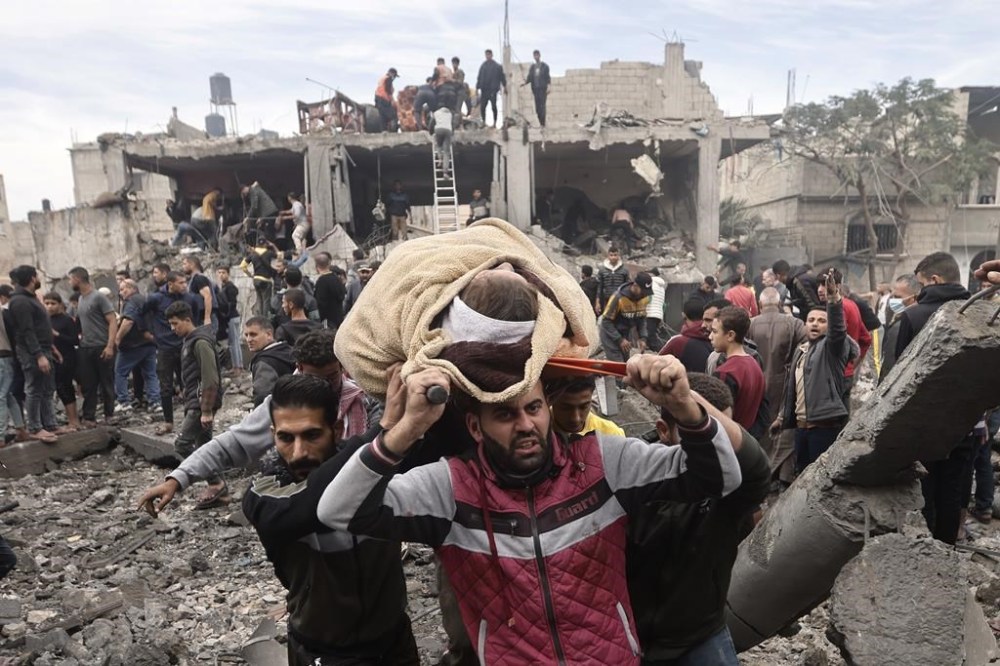 Palestinians evacuate a wounded woman following Israeli airstrikes in Khan Younis refugee camp, southern Gaza Strip, Thursday, Dec. 7, 2023. (AP Photo/Mohammed Dahman)