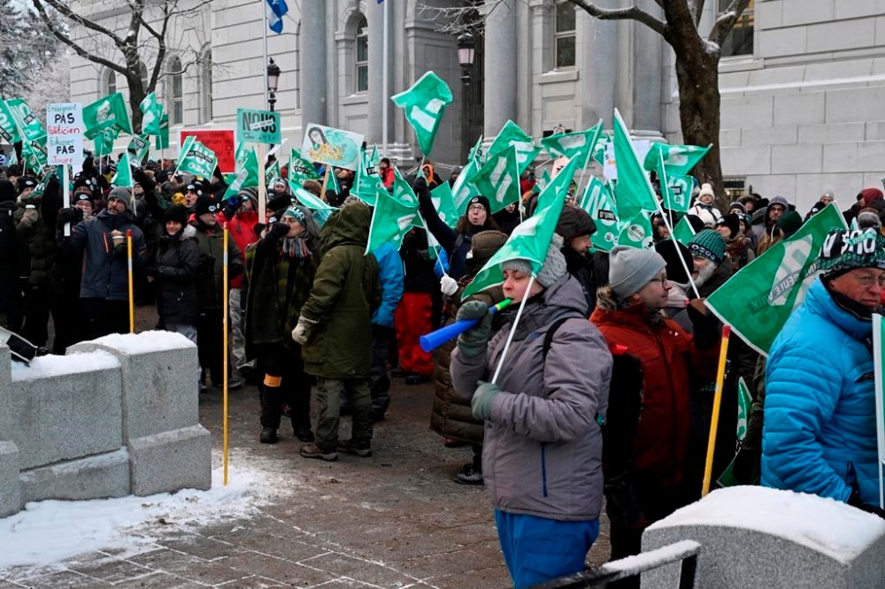 Common front union members demonstrate, blocking the entrance of the National Assembly, as the fall session comes to an end, Friday, Dec. 8, 2023, at the legislature in Quebec City. THE CANADIAN PRESS/Jacques Boissinot