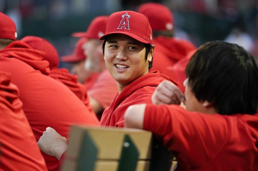 Los Angeles Angels' Shohei Ohtani talks with his translator Ippei Mizuhara, right, in the dugout during the first inning of a baseball game against the Oakland Athletics in Anaheim, Calif., Saturday, Sept. 30, 2023. THE CANADIAN PRESS/AP-Ashley Landis