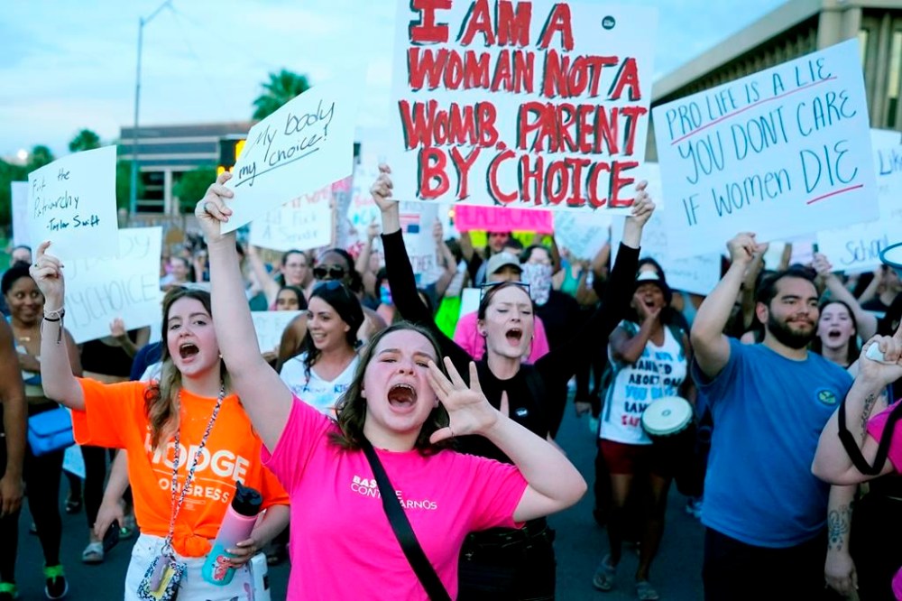 FILE - Protesters in Phoenix shout as they join thousands marching around the Arizona state Capitol after the U.S. Supreme Court decision to overturn the landmark Roe v. Wade abortion decision on June 24, 2022. Three state supreme courts are scheduled to hear arguments in abortion-related cases this week. (AP Photo/Ross D. Franklin, File)