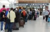 People line up before entering the security zone at Pearson International Airport in Toronto on Friday, August 5, 2022. A full tourism recovery is not expected until next year, Destination Canada says. THE CANADIAN PRESS/Nathan Denette