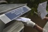 FILE - A woman wearing gloves drops off a mail-in ballot at a drop box in Hackensack, N.J., on July 7, 2020. Federal prosecutors and lawyers for Donald Trump have signaled their desire to invoke the 2016 election in the former president's trial on charges of scheming to overturn the results of the 2020 presidential election. (AP Photo/Seth Wenig, File)