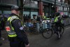 Police officers stand by while an unhoused person collects their belongings as city workers with the assistance of Vancouver police continue for the second day to remove tents and structures from encampments, in the Downtown Eastside of Vancouver, B.C., Thursday, April 6, 2023. British Columbia's Human Rights Commissioner is launching an inquiry into police restrictions on media covering the decampment in Vancouver's Downtown Eastside. THE CANADIAN PRESS/Darryl Dyck