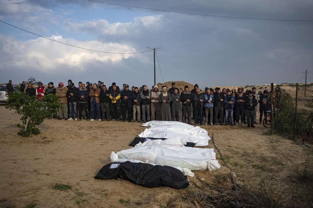 Palestinians pray over bodies of their relatives killed in the Israeli bombardment of the Gaza Strip, at a cemetery in Rafah, southern Gaza, Thursday, Dec. 14, 2023. (AP Photo/Fatima Shbair)