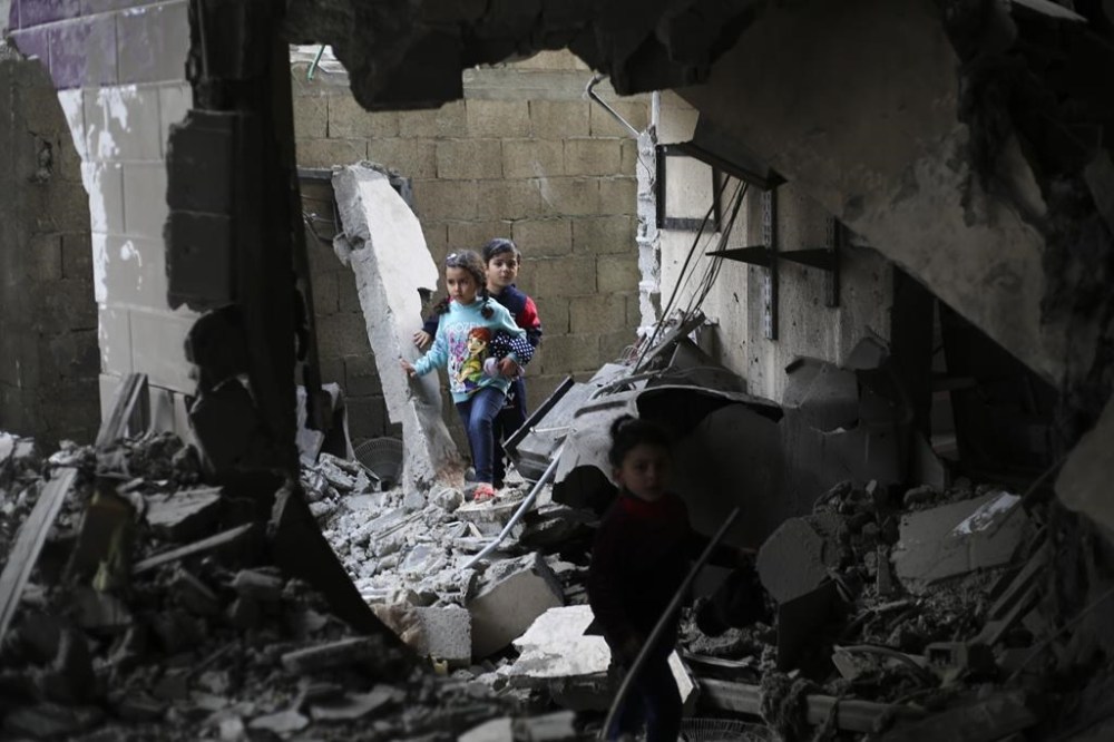 Palestinian children walk after an Israeli strike on residential buildings in Rafah, Gaza Strip, on Thursday, Dec. 14, 2023. (AP Photo/Hatem Ali)