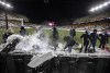 Crews clean snow off the field before a World Cup qualifying soccer match between Canada and Mexico, in Edmonton, Tuesday, Nov. 16, 2021. THE CANADIAN PRESS/Jason Franson