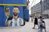People walk past a mural of Argentina's soccer star Lionel Messi in the Padre Carlos Mugica neighborhood of Buenos Aires, Argentina, Thursday, Dec. 14, 2023. (AP Photo/Rodrigo Abd)
