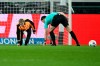 Referee Felix Zwayer, right, and a steward pick up objects thrown onto the pitch by fans during the Bundesliga soccer match between Borussia Monchengladbach and Werder Bremen at the Borussia-Park stadium in Monchengladbach, Germany, Friday Dec. 15, 2023. (Federico Gambarini/dpa via AP)