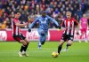 Aston Villa's Moussa Diaby, centre, battles for the ball with Brentford's Christian Norgaard, left and Ben Mee, during the English Premier League soccer match between Brentford and Aston Villa at the Gtech Community Stadium, in London, Sunday, Dec. 17, 2023. (Jonathan Brady/PA via AP)