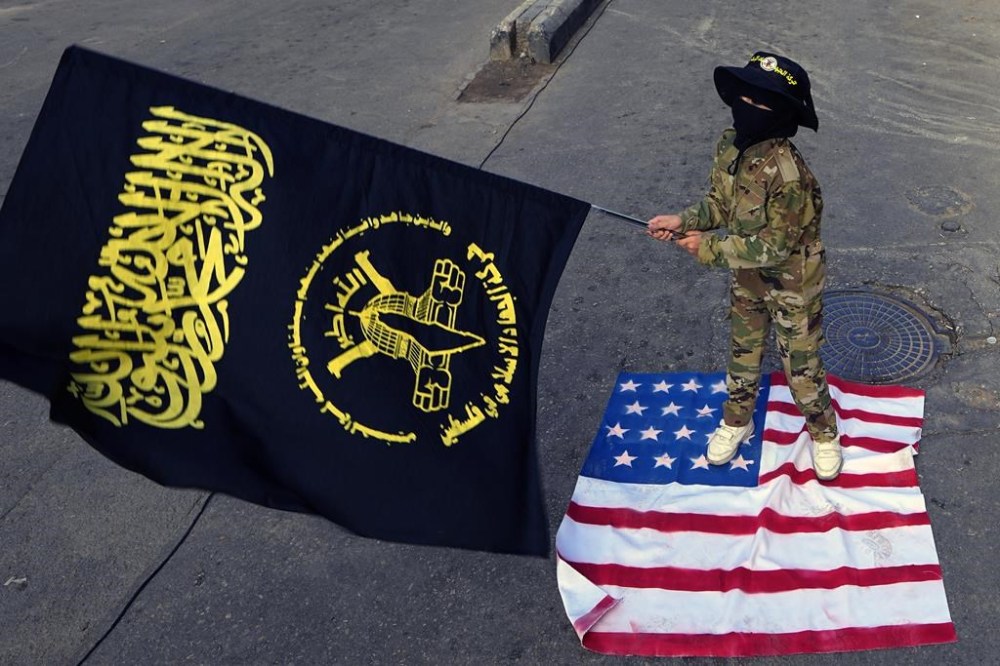 A child waves the Palestinian Islamic Jihad group flag as she stands on an American flag during a protest in solidarity with the Palestinian people in Gaza, at Bourj al-Barajneh Palestinian refugee camp, in Beirut, Lebanon, Sunday, Dec. 17, 2023. (AP Photo/Bilal Hussein)