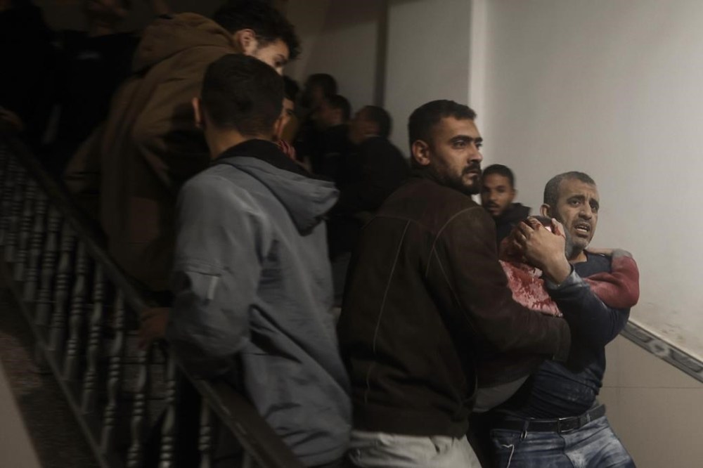 Palestinians evacuate a wounded boy following Israeli strikes on the maternity ward at Nasser Hospital in the town of Khan Younis, southern Gaza Strip, Sunday, Dec. 17, 2023. (AP Photo/Mohammed Dahman)
