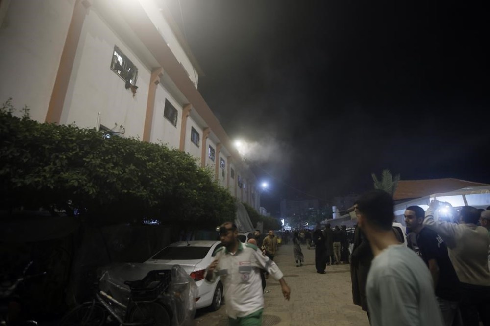 Palestinians look at smoke raising from the patient rooms following Israeli strikes on the maternity ward at Nasser Hospital in the town of Khan Younis, southern Gaza Strip, Sunday, Dec. 17, 2023. (AP Photo/Mohammed Dahman)