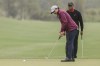 Tiger Woods, background, watches son Charlie, foreground, putt during the final round of the PNC Championship golf tournament, Sunday, Dec. 17, 2023, in Orlando, Fla. (AP Photo/Kevin Kolczynski)
