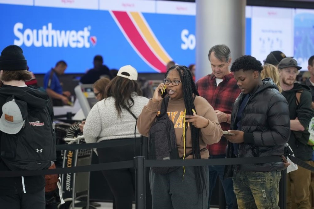 FILE - Travelers wait in line for service at the Southwest Airlines check-in counter at Denver International Airport on Dec. 27, 2022. Southwest Airlines will pay a $35 million fine as part of a $140 million agreement to settle a federal investigation into a debacle last December when the airline canceled thousands of flights and stranded more than 2 million travelers over the holidays. (AP Photo/David Zalubowski, File)