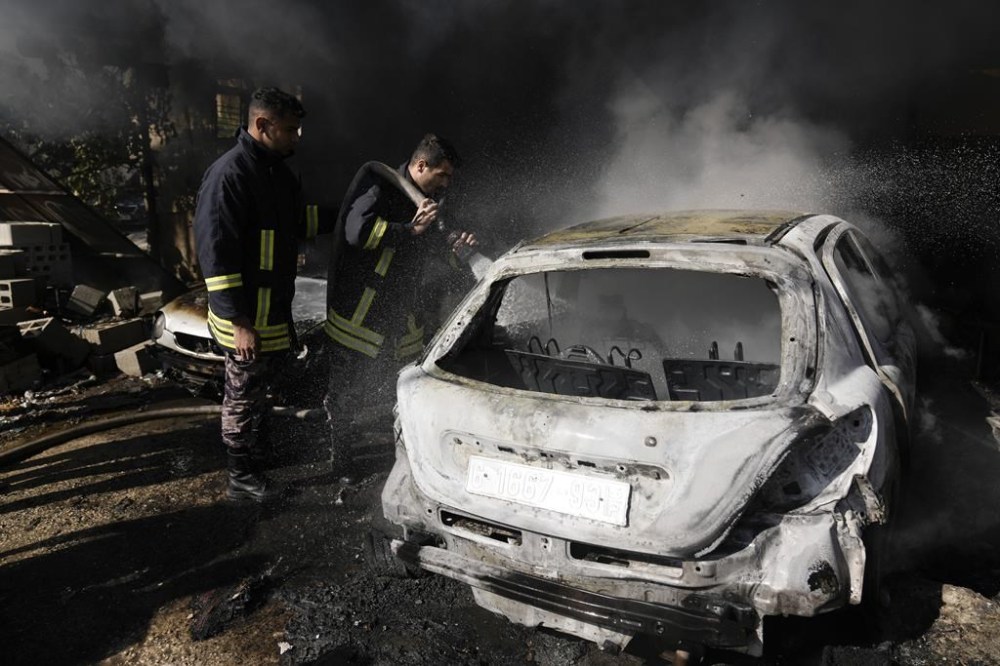 Palestinian firefighters extinguish cars after an Israeli military raid on the Fara'a refugee camp in the West Bank on Monday, Dec. 18, 2023. (AP Photo/Majdi Mohammed)