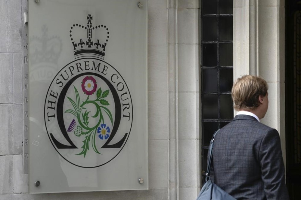 FILE - A man enters the Supreme Court in London, on Oct. 9, 2023. An artificial intelligence system can't be registered as the inventor of a patent, Britain's Supreme Court ruled on Wednesday Dec. 20, 2023 in a decision denying machines the same status as humans. (AP Photo/Kin Cheung, File)