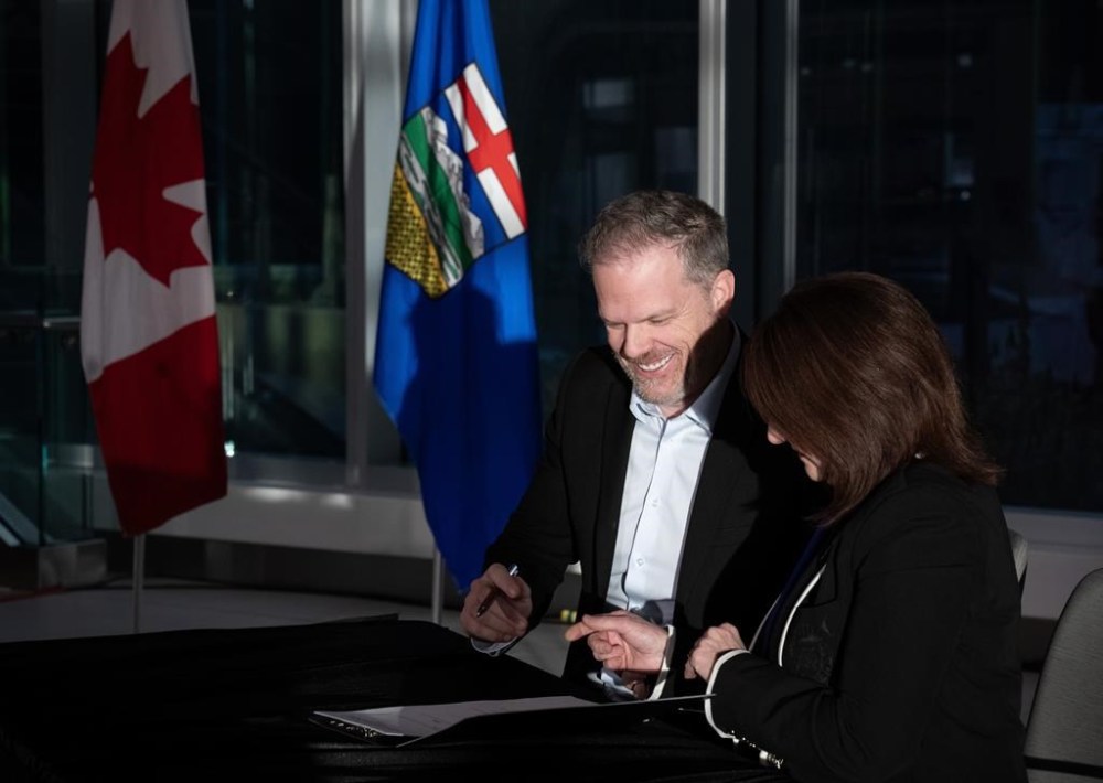 Canada's Minister of Health Mark Holland signs an agreement with Adriana LaGrange, minister of health for Alberta, in Calgary on Thursday, Dec. 21, 2023. THE CANADIAN PRESS/Todd Korol