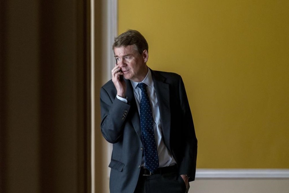 FILE - Sen. Michael Bennet, D-Colo., speaks on a cellphone in a hallway as the House approved a 45-day funding bill to keep federal agencies open, Saturday, Sept. 30, 2023, in Washington. As the Senate wrapped up its work for the year, Bennet took to the floor of the nearly empty chamber and made a late-night plea for Congress to redouble support for Ukraine: “Understand the stakes at this moment.