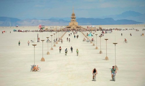 FILE - People walk toward the temple at Burning Man near Gerlach, Nev., on the Black Rock Desert, Friday, Aug. 31, 2012. Burning Man organizers don't foresee major changes in 2024 thanks to a hard-won passing grade for cleaning up this year's festival. Some question whether it has veered too far from its core principles of radical inclusion and participation. (Andy Barron/The Reno Gazette-Journal via AP, File)
