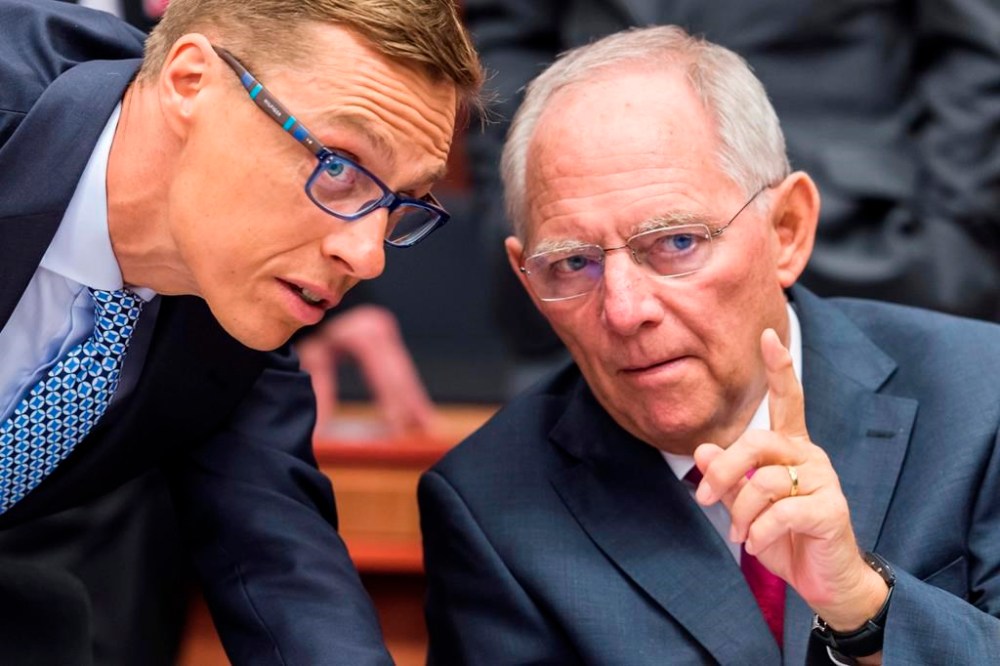 FILE - German Finance Minister Wolfgang Schaeuble, right, talks with Finnish Finance Minister Alexander Stubb during a meeting of eurogroup finance ministers at the EU Council building in Brussels on Monday, July 13, 2015. Wolfgang Schaeuble, who helped negotiate German reunification in 1990 and as finance minister was a central figure in the austerity-heavy effort to drag Europe out of its debt crisis more than two decades later, has died on Tuesday, Dec. 26, 2023. He was 81. (AP Photo/Geert Vanden Wijngaert, File)