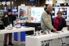 FILE - Bob Adkison, center, and his wife Rosie, right, browse computer tablets at a Best Buy store, Friday, Nov. 24, 2023, in Charlotte, N.C. Preparing for a midnight toast and more year-end festivities may require a run or two to the store — but you’ll want to prepare for some limited business hours.(AP Photo/Erik Verduzco, File)
