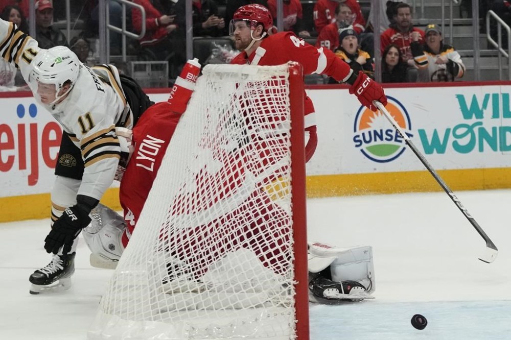 Boston Bruins center Trent Frederic (11) shoots the puck past Detroit Red Wings goalie Alex Lyon for a goal during the first period of an NHL hockey game, Sunday, Dec. 31, 2023, in Detroit. (AP Photo/Carlos Osorio)