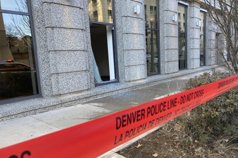 Police tape blocks the damage to large windows at the Colorado Supreme Court on Tuesday, Jan. 2, 2024 in Denver. Authorities say a man inflicted