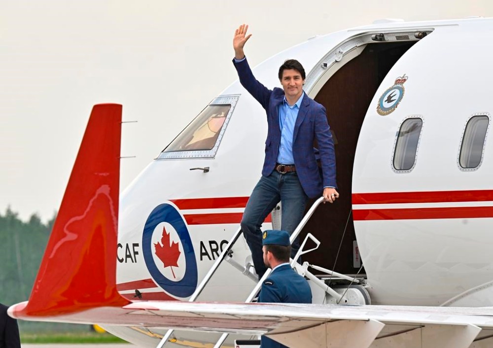 Prime Minister Justin Trudeau waves as he steps off a plane, Wednesday, June 14, 2023 at CFB Bagotville in Saguenay, Que. The plane that flew Trudeau to Jamaica for a family vacation broke down earlier this week, prompting the Canadian military to send a second aircraft with a repair crew to the Caribbean island. THE CANADIAN PRESS/Jacques Boissinot