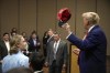 Former President Donald Trump hols up a hat he signed after speaking at a rally at Des Moines Area Community College in Newton, Iowa, Saturday, Jan. 6, 2024. (AP Photo/Andrew Harnik)