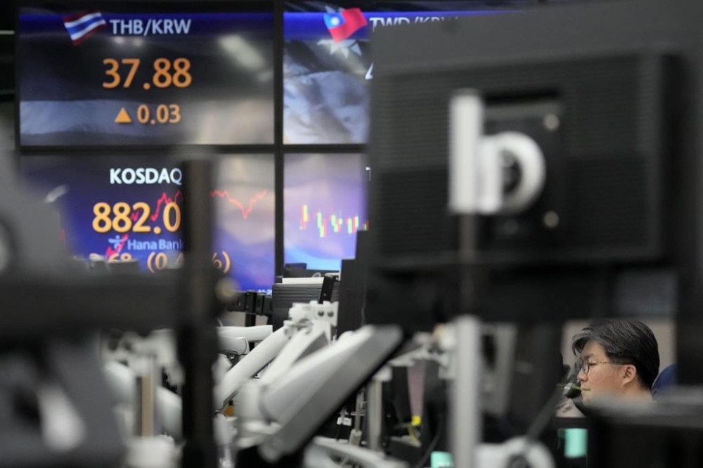 A currency trader watches computer monitors near the screens showing the Korean Securities Dealers Automated Quotations (KOSDAQ), and the foreign exchange rate at a foreign exchange dealing room in Seoul, South Korea, Monday, Jan. 8, 2024. Major Asian stock markets traded lower after Wall Street closed its worst week since Halloween with a listless Friday.(AP Photo/Lee Jin-man)
