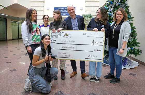 Students from Dakota Collegiate, which held a fundraising campaign for the Christmas Cheer Board, present Free Press editor Paul Samyn, a cheque for $10,755 for Miracle on Mountain. Find out how to contribute. (Ruth Bonneville / Winnipeg Free Press)