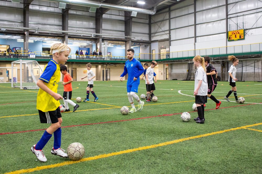 BROOK JONES / WINIPEG FREE PRESS 
 Marco Bustos, 27, who grew up in the Maples, leads a ball control soccer drill for youth players during a soccer camp Winnipeg Soccer Federation South at the University of Manitoba Fort Garry campus in Winnipeg, Man., Friday, Dec. 29, 2023.