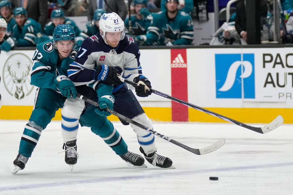 Winnipeg Jets left wing Nikolaj Ehlers battles for puck possession with San Jose Sharks left wing William Eklund during the second period. (AP Photo/Jeff Chiu)