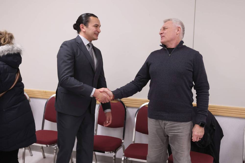 Manitoba Premier Wab Kinew shakes hands and chats with Dauphin Mayor David Bosiak after the press conference. (Tim Smith / The Brandon Sun)