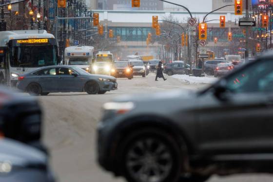 People cross Portage Avenue on Wednesday as snow begins to fall. (Mike Deal / Winnipeg Free Press)