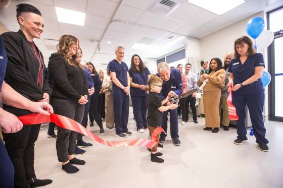 Dr. Gordon McTavish, medical director, cuts the ribbon for the new Heartland Fertility clinic with help from four-year-old Smith Warnick on Thursday. (Mikaela MacKenzie / Winnipeg Free Press)