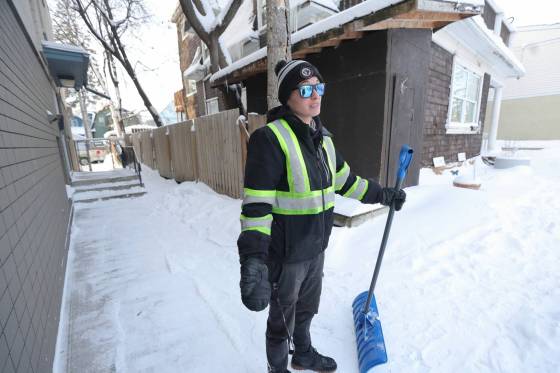 Steph Jones, a tenant and caretaker at 142 Furby St., shovels snow outside the townhouse Friday, a day after she helped a neighbour who had been shot on the West Broadway street. (Ruth Bonneville / Winnipeg Free Press)