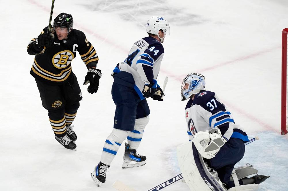 (AP Photo/Michael Dwyer)
Boston Bruins’ Brad Marchand celebrates a goal by teammate Trent Frederic during the first period of the Bruins 4-1 win over the Jets, Monday in Boston. The loss saw the end to the Jets streak of surrendering three-or-fewer goals at 34 games.