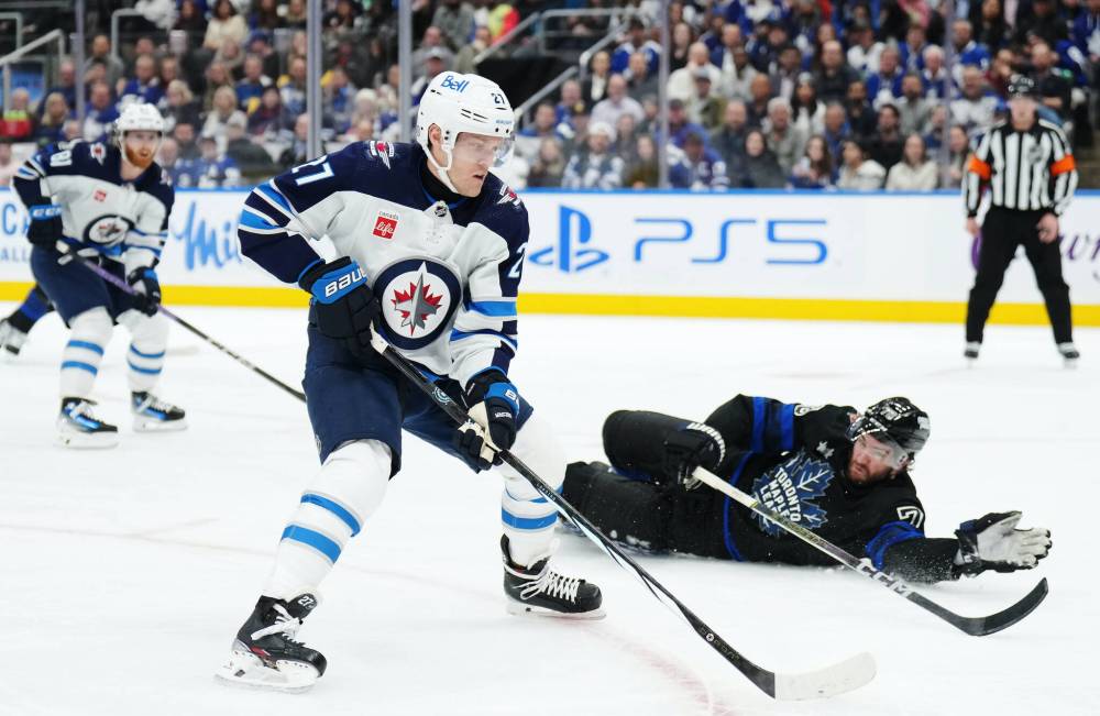 Nathan Denette / THE CANADIAN PRESS
Nikolaj Ehlers skates arounf Maple Leafs defenceman TJ Brodie Wednesday in Toronto. The rematch is Saturday night in downtown Winnipeg.