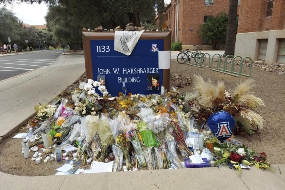 FILE - A memorial for University of Arizona professor Thomas Meixner is seen outside the school's Department of Hydrology and Atmospheric Sciences building, Oct. 14, 2022, in Tucson, Ariz. The family of the University of Arizona professor who was fatally shot on campus in the fall of 2022 has reached a multi-million-dollar agreement with the school, attorneys for the man's wife and sons said Tuesday, Jan. 9, 2024. (AP Photo/Terry Tang, File)