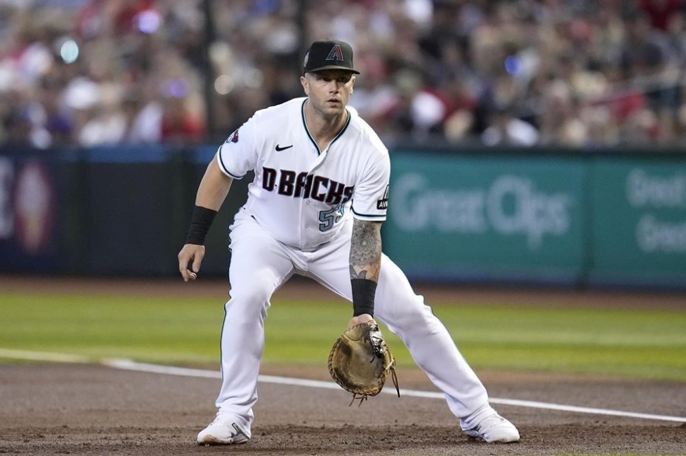 FILE - Arizona Diamondbacks first baseman Christian Walker watches a pitch during the first inning of the team's baseball game against the Cincinnati Reds on Aug. 27, 2023, in Phoenix. Th Diamondbacks and Walker agreed to a $10.9 million, one-year deal Thursday, Jan. 11, 2024, avoiding salary arbitration. Walker has been one of the most well-rounded first baseman in the big leagues over the past two years and was a huge piece for the D-backs during their recent run to the World Series. (AP Photo/Ross D. Franklin, File)