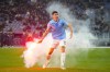 Lazio's Alessio Romagnoli holds a flare which was thrown onto the pitch during the quarterfinal Italian Cup soccer match between Lazio and Roma at Rome's Olympic Stadium, Wednesday, Jan. 10, 2024. (AP Photo/Gregorio Borgia)