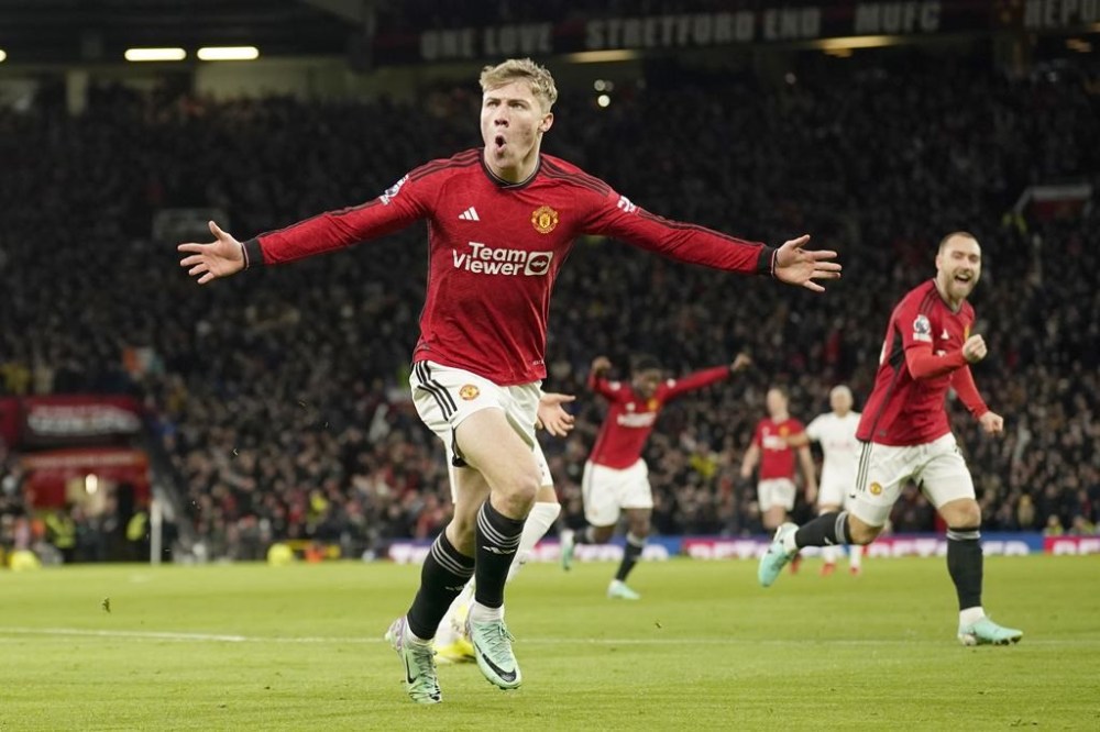 Manchester United's Rasmus Hojlund celebrates with teammates after scoring his side's opening goal during the English Premier League soccer match between Manchester United and Tottenham Hotspur at the Old Trafford stadium in Manchester, England, Sunday, Jan.14, 2024. (AP Photo/Dave Thompson)