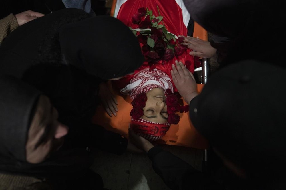 Palestinian mourners take the last look at the body of Suleiman Kanan, 17, during his funeral in the West Bank town of Bir Zeit, Monday, Jan. 15, 2024. Palestinian Health Ministry said that Suleiman Kanan, 17, and Khaled Humeidat, 16, were killed by Israeli army fire last night near the northern entrance of Ramallah. Humeidat's body was not released to his family by the Israeli army. The Israeli army said troops of the 636th Combat Intelligence Collection unit carrying out